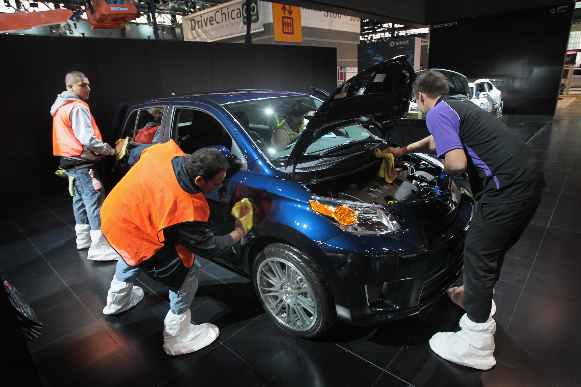 Workers prepare a royal-blue metallic 2012 Scion XD for display at the Chicago Auto Show on February 7, 2012, in Chicago, Illinois