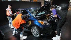 Workers prepare a royal-blue metallic 2012 Scion XD for display at the Chicago Auto Show on February 7, 2012, in Chicago, Illinois