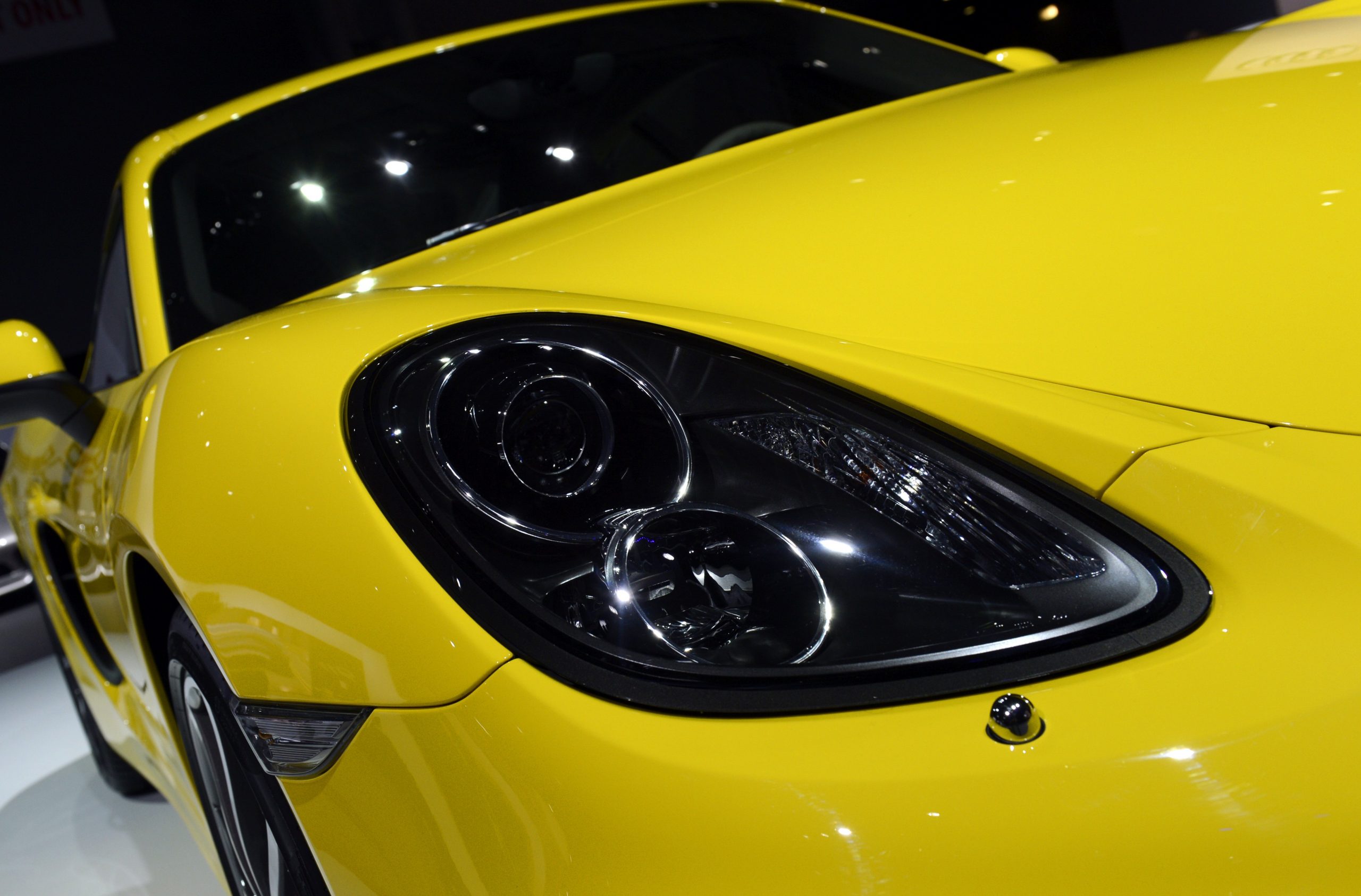 Closeup of a yellow 2014 Porsche Cayman coupe