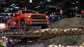 An orange 2015 Toyota Tundra traverses a road test