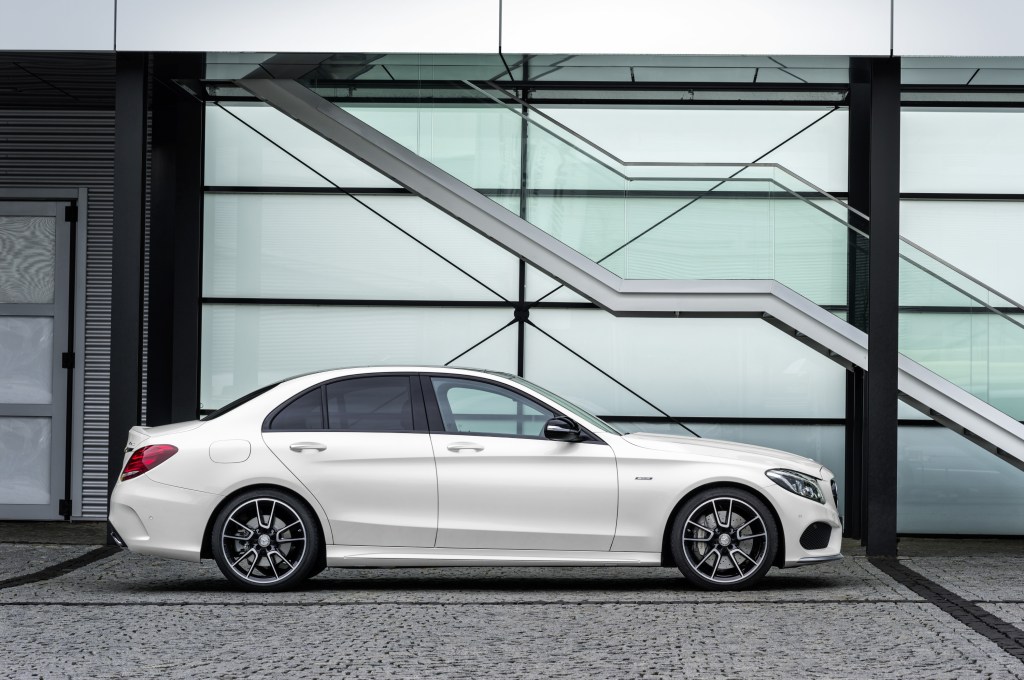 A white 2016 Mercedes-Benz C450 AMG 4MATIC parked next to an artsy wall