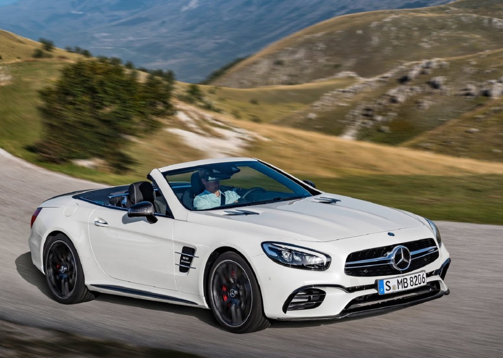 A white 2017 Mercedes-Benz SL 63 AMG driving through the mountains with its roof down