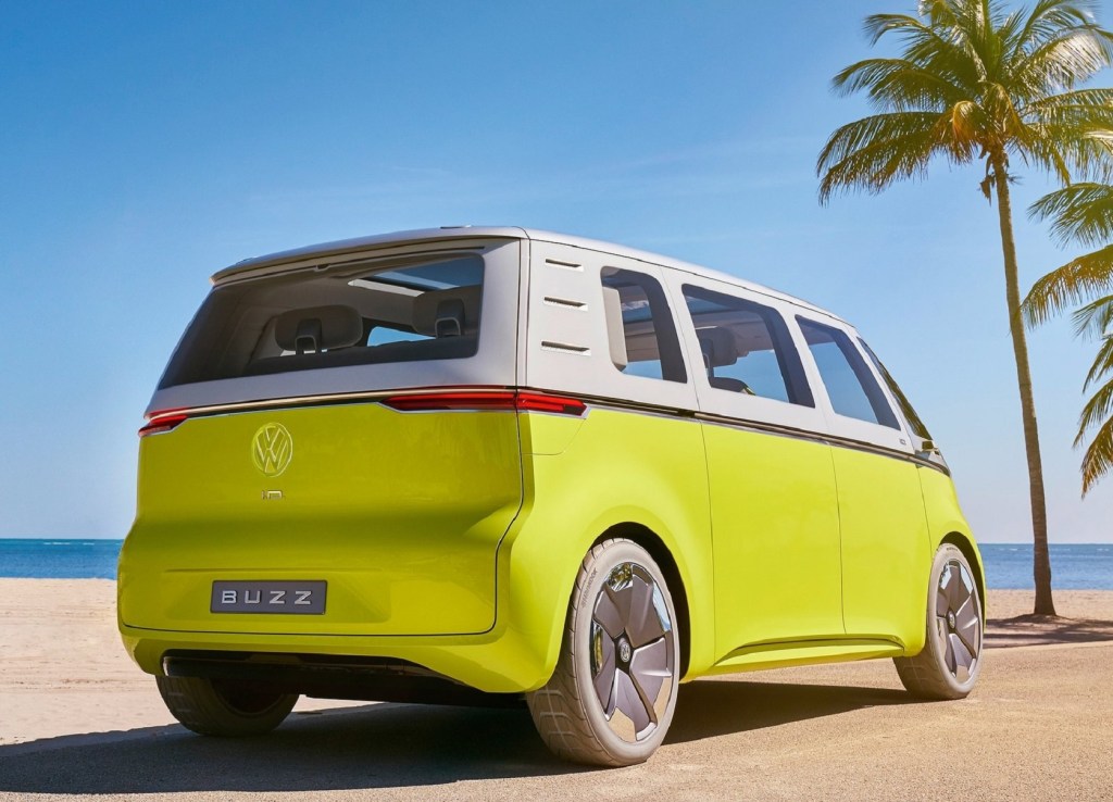 The rear 3/4 view of a yellow-and-silver 2017 Volkswagen ID.Buzz Concept parked on a sandy beach