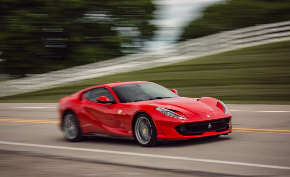 A 2018 Ferrari 812 Superfast accelerating down country road 