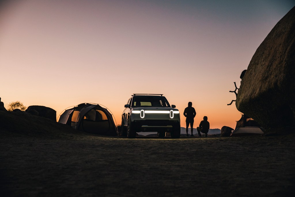 The Rivian electric SUV, the R1S parked in the desert at dusk