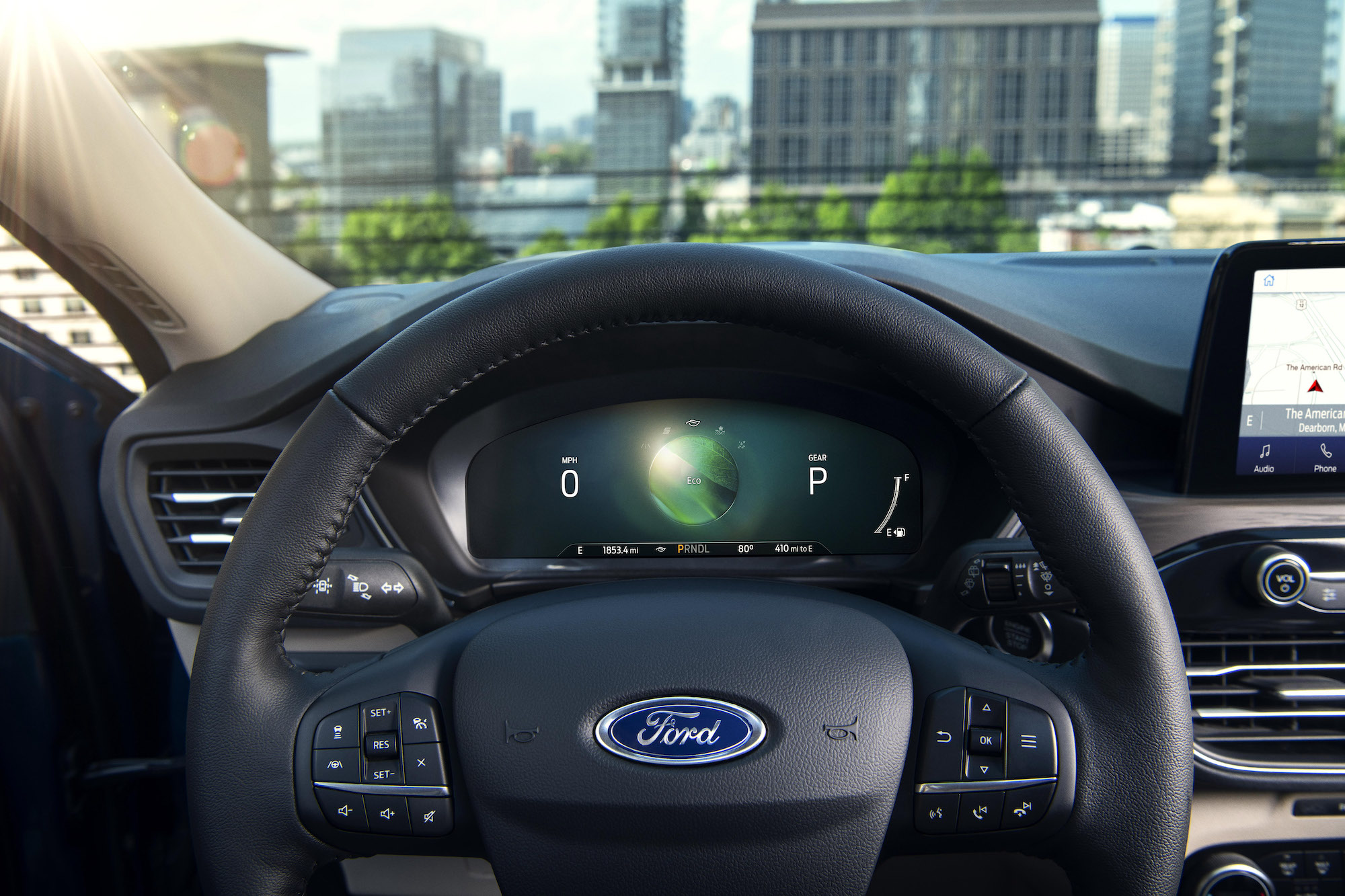 The black steering wheel and instrumentation panel of a 2020 Ford Escape Hybrid compact crossover SUV