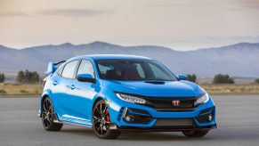A blue 2020 Honda Civic Type R parked on display with a mountain range in the background