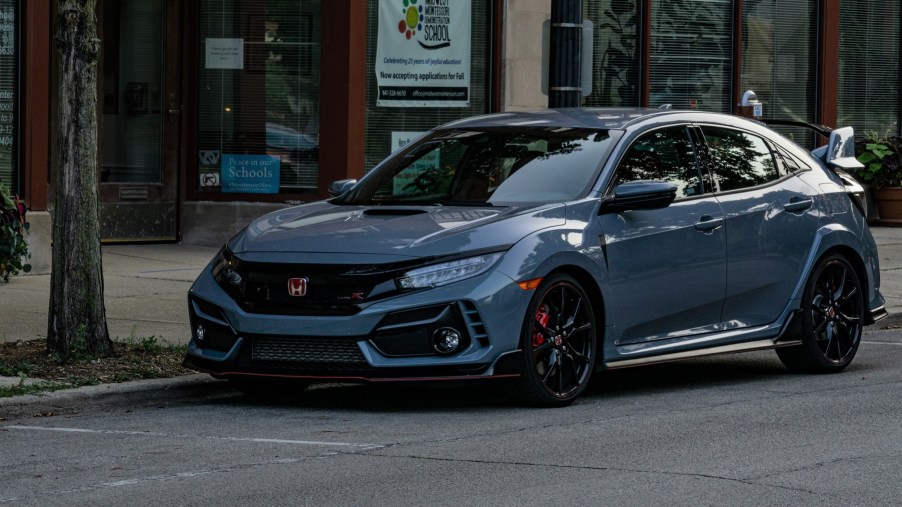 A gray 2020 Honda Civic Type R parked on the street by some shops