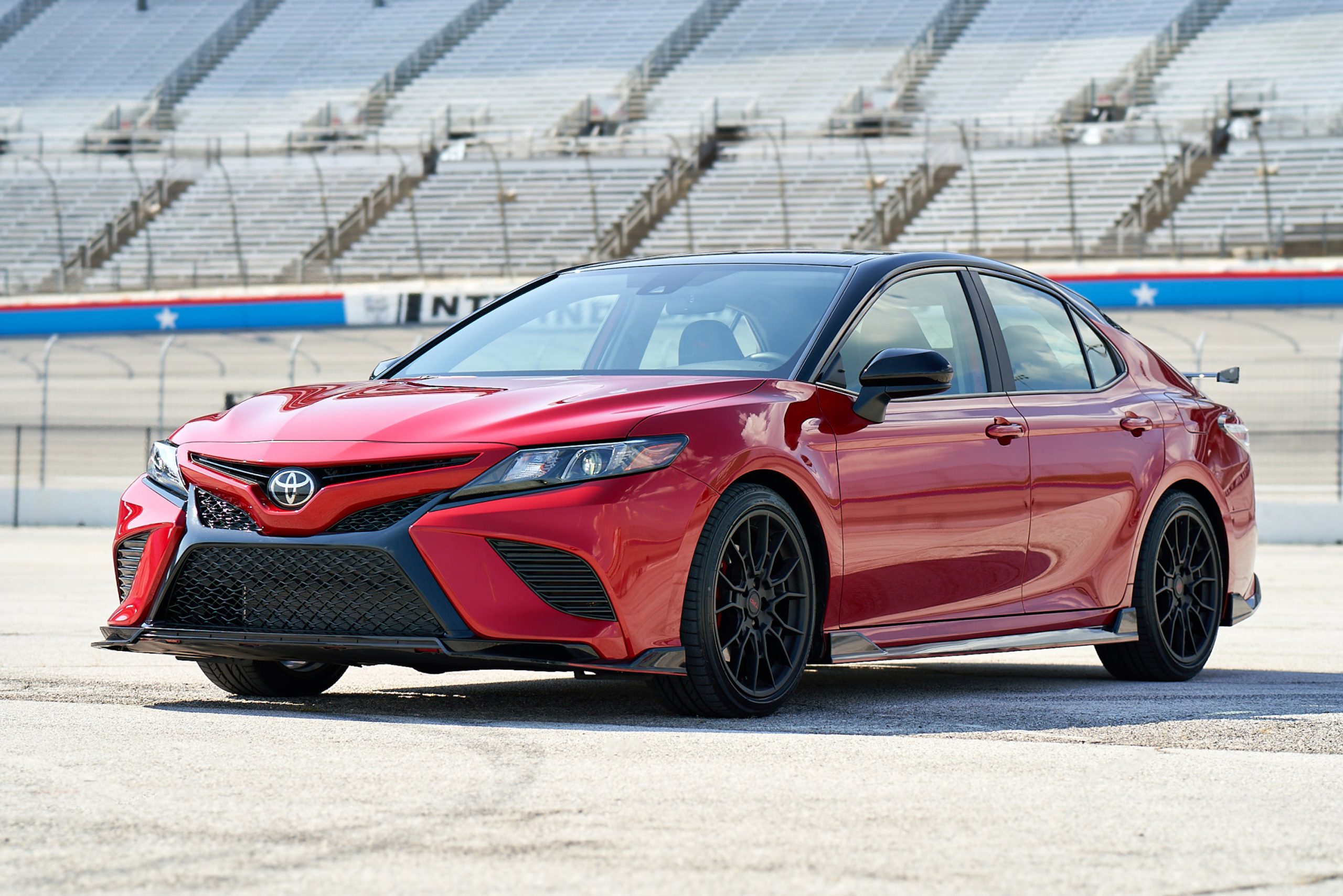 A red 2020-2021 Toyota Camry TRD parked on a racetrack
