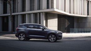 A 2020 Volvo XC40 compact luxury SUV with Denim Blue metallic exterior paint turning a corner next to a modern office building