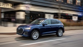 A dark-blue 2021 Audi Q5 compact SUV traveling on a city street