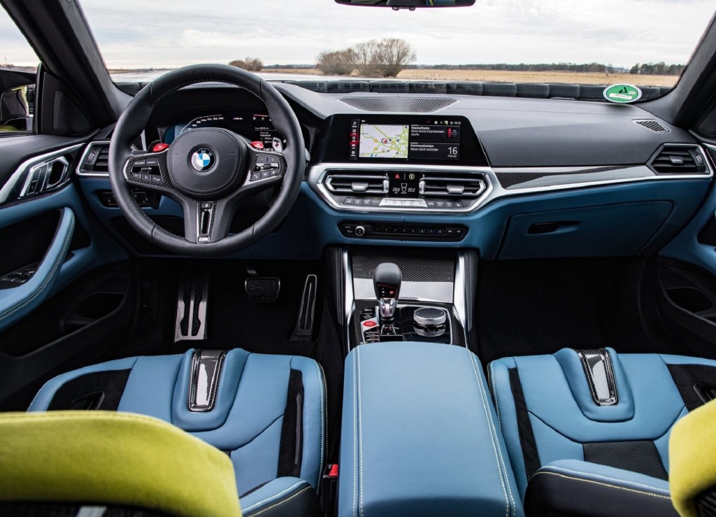 The blue-leather-trimmed carbon-fiber front seats and black carbon-fiber-trimmed dashboard of the 2021 BMW M4 Competition