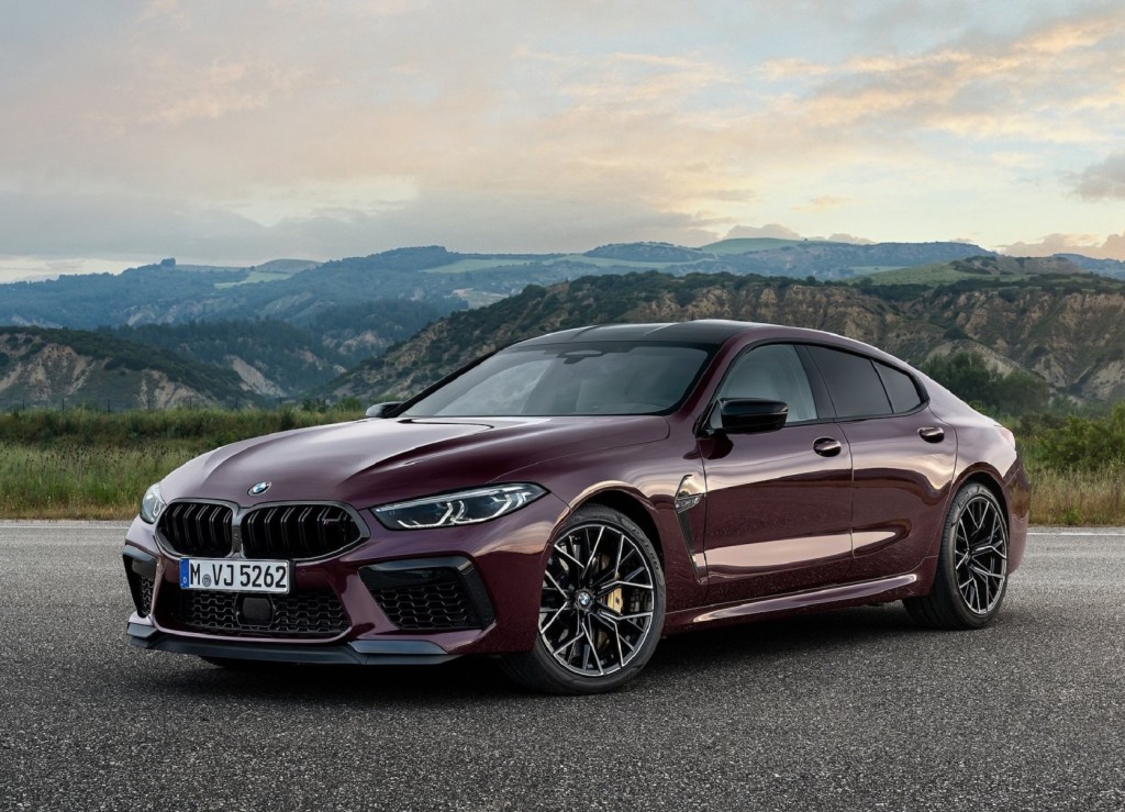 A dark-purple 2021 BMW M8 Competition Gran Coupe parked on a mountain-side overlook