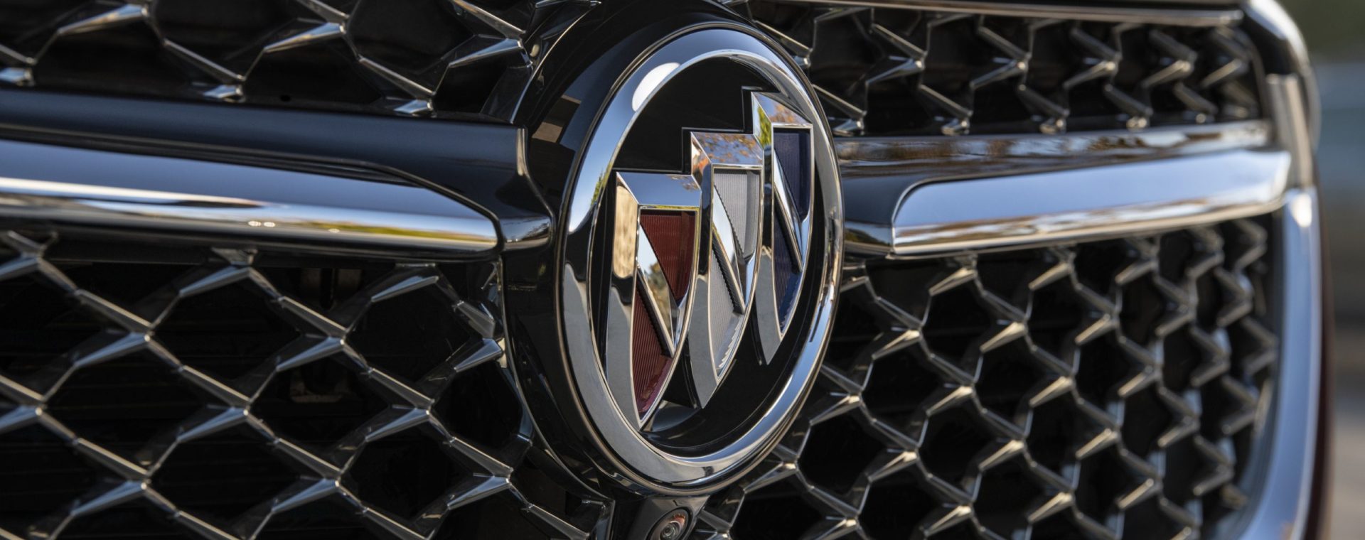 A close-up look at the luxurious Buick logo on the grille of a 2021 Buick Envision Avenir