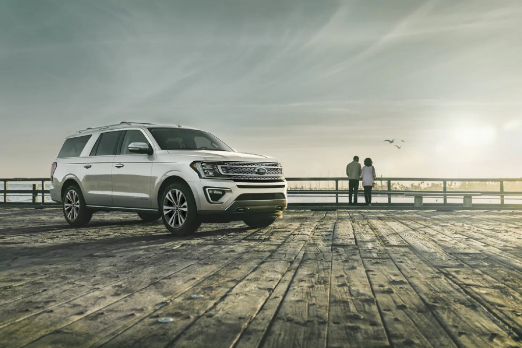 A white 2021 Ford Expedition Platinum on an ocean boardwalk with a couple in the distance