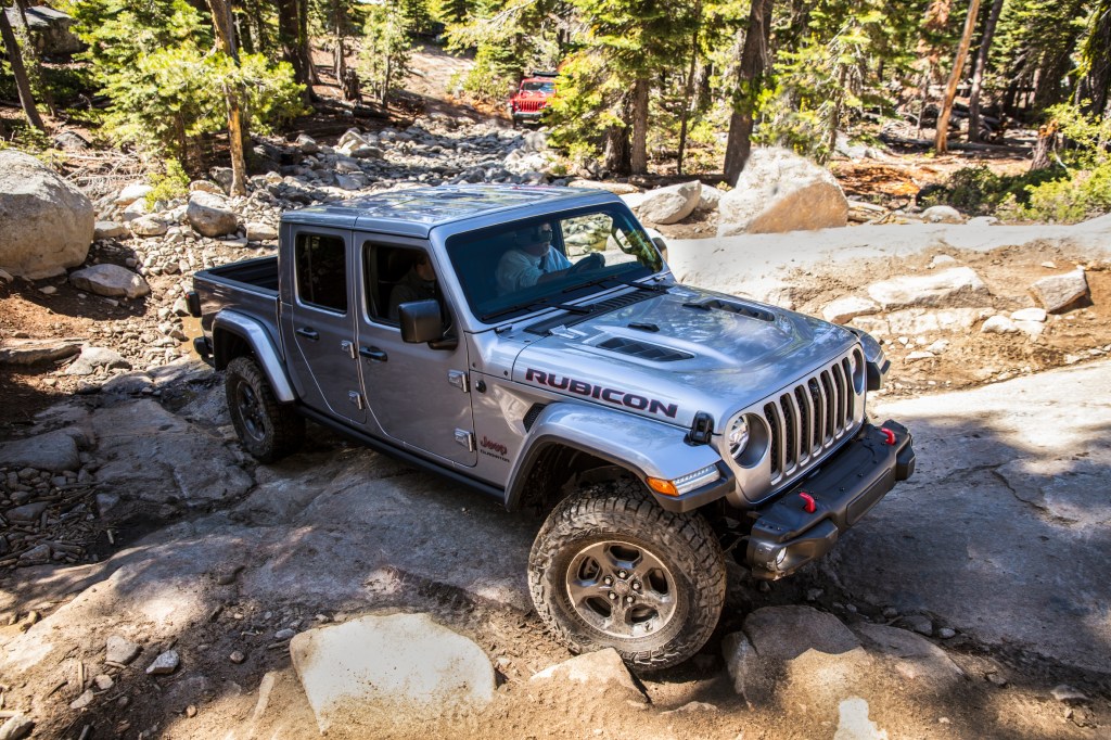 A silver 2021 Jeep Gladiator Rubicon climbing up a rocky incline