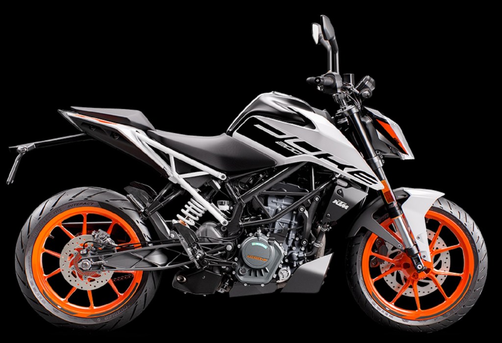 The side view of a white-and-black 2021 KTM 200 Duke with orange wheels