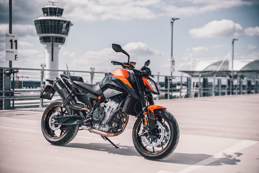 An orange-and-black 2021 KTM 890 Duke with an optional exhaust on an airport bridge
