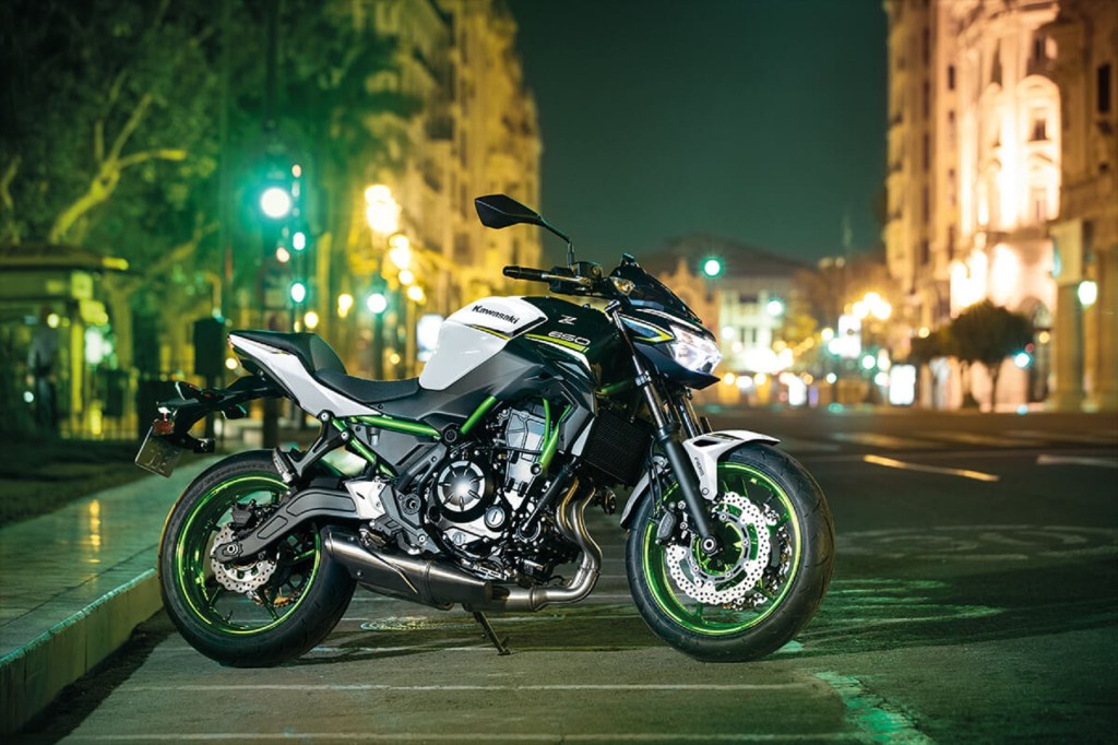 A white-black-and-green 2021 Kawasaki Z650 on a well-lit city street at night