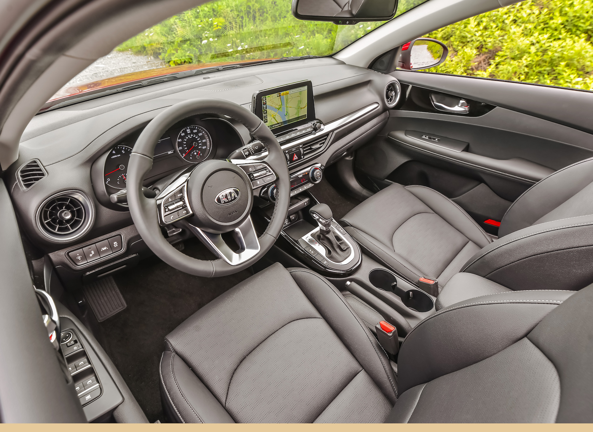The gray front seats, steering wheel, and dashboard of a 2021 Kia Forte compact sedan