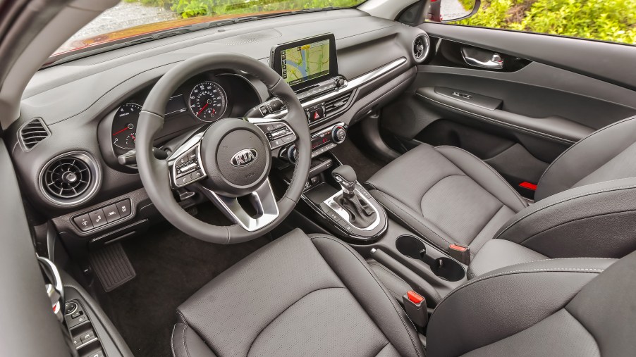 The gray front seats, steering wheel, and dashboard of a 2021 Kia Forte compact sedan