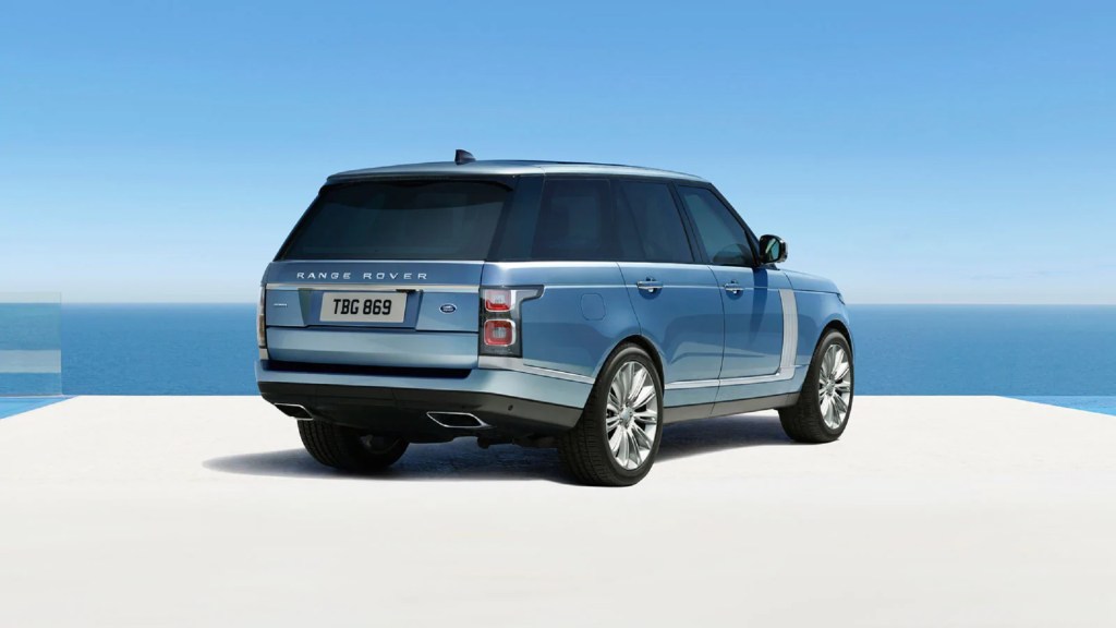 The rear 3/4 view of a blue-and-silver 2021 Land Rover Range Rover Autobiography by the ocean