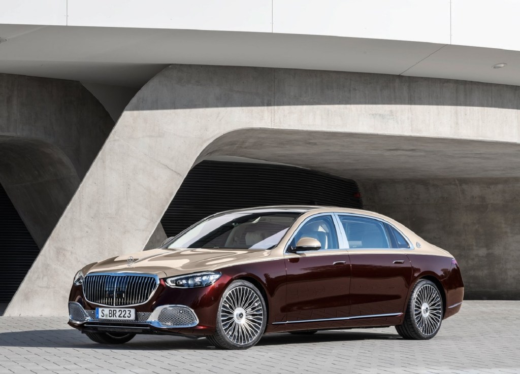 A two-tone gold-and-maroon 2021 Mercedes-Maybach S-Class in front of a concrete building