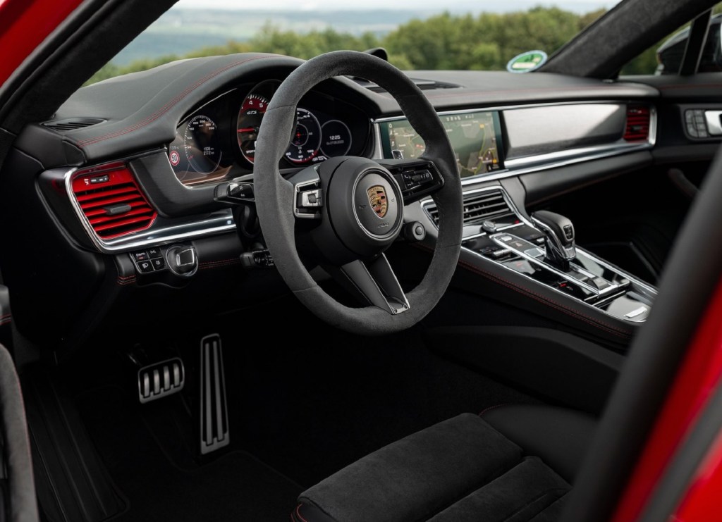 The black-suede-trimmed front seats and dashboard of a red 2021 Porsche Panamera GTS