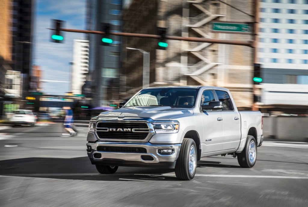 A silver 2021 Ram 1500 Big Horn four-door full-size pickup truck turning in a city intersection