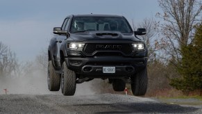 A black 2021 Ram 1500 TRX jumping through the air above a gravel road