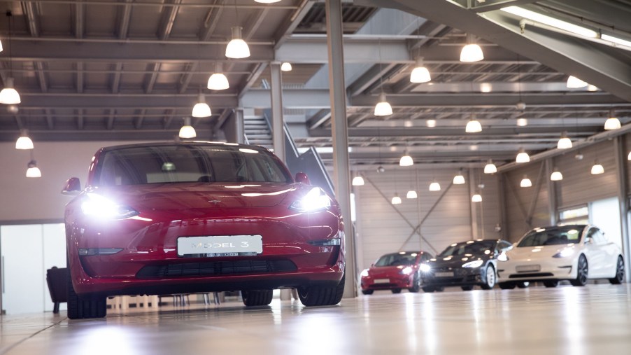A red Tesla Model 3 EV and other models at the Tesla Service Center in Hamburg, Germany, on October 21, 2020