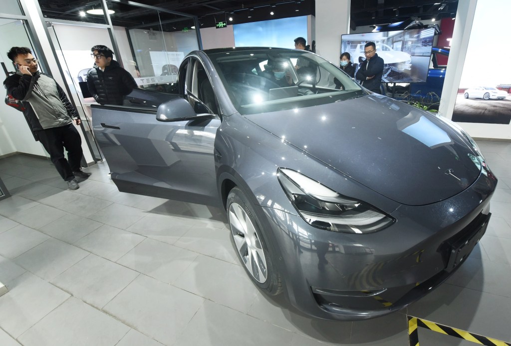 Customers look at the first Tesla Model Y electric SUV arriving at a Tesla store in Hangzhou, Zhejiang Province, China, on January. 4, 2021