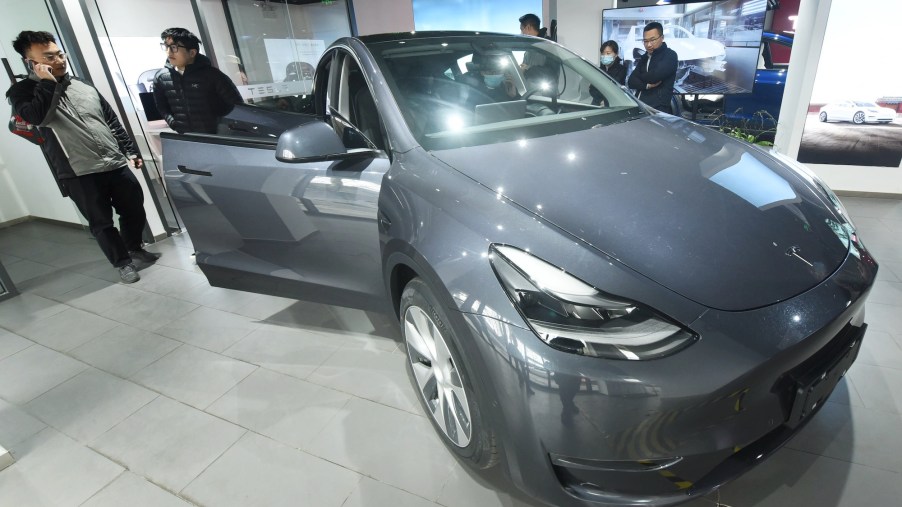 Customers look at the first Tesla Model Y electric SUV arriving at a Tesla store in Hangzhou, Zhejiang Province, China, on January. 4, 2021
