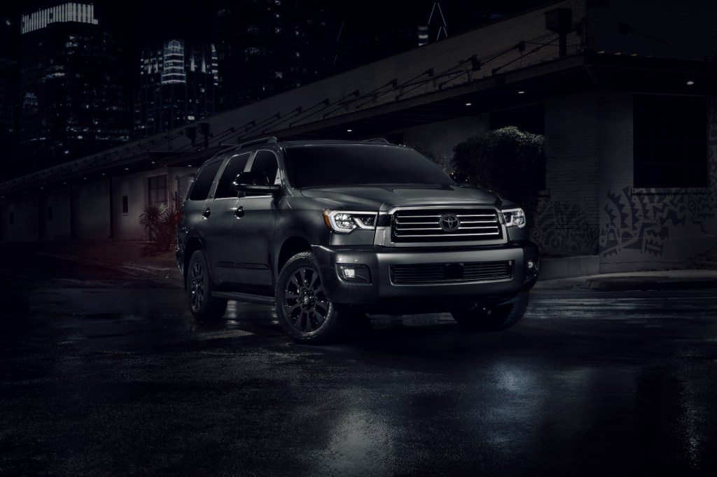 A dark-gray 2021 Toyota Sequoia Nightshade large SUV on a city street at night