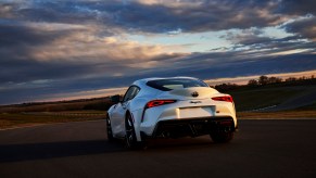 A rear view of a white 2021 Toyota GR Supra 3.0 Premium sitting on a racetrack