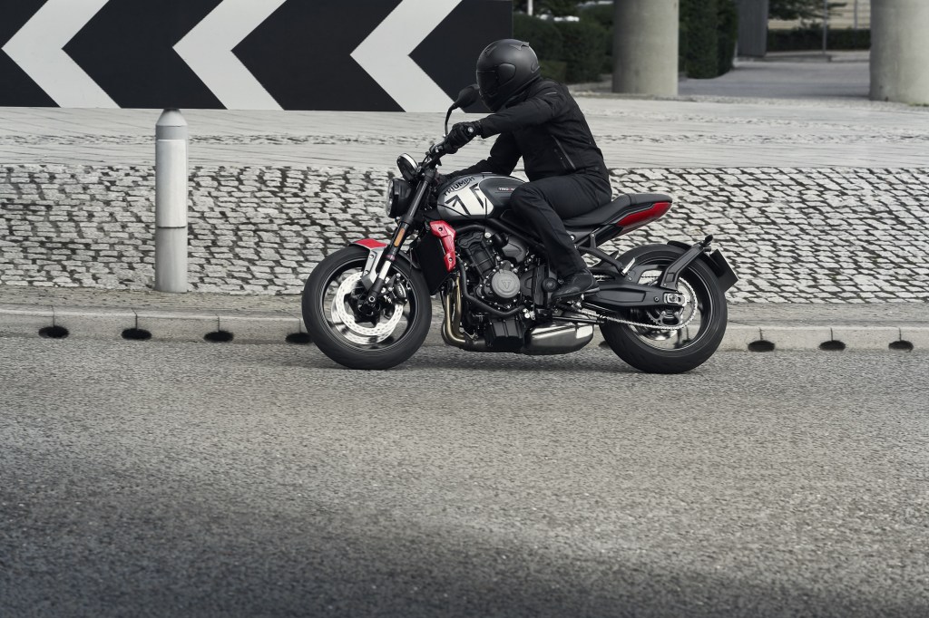 A black-clad rider takes the gray-and-black 2021 Triumph Trident 660 around a street corner