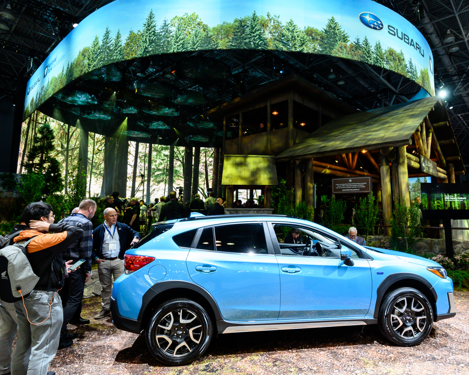 A blue 2021 Subaru Crosstrek Hybrid on a nature display at the New York Auto Show