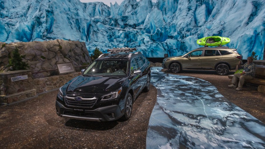Some Subaru Outbacks traverse snowy terrain at an auto show