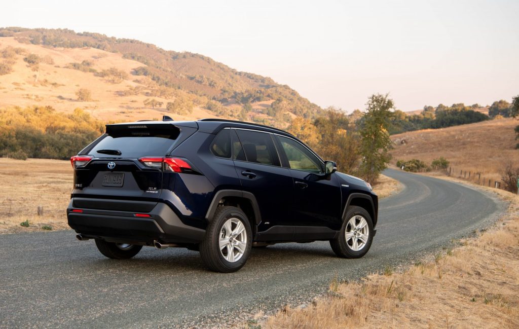 2021 Toyota RAV4 Hybrid in blue shot from the rear on a country road.