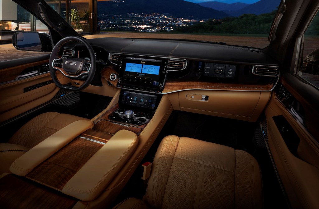 The tan-leather front seats and walnut-lined dashboard of a 2022 Jeep Grand Wagoneer
