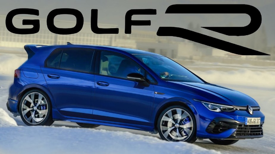 A blue 2022 Volkswagen Golf R drifts through the snow