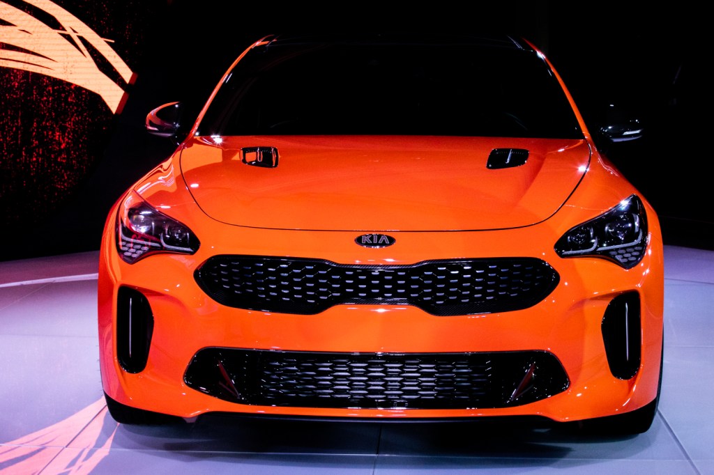 An orange Kia Stinger on display at a car event