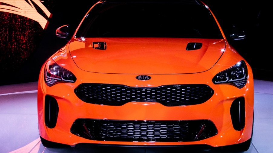 An orange Kia Stinger on display at a car event