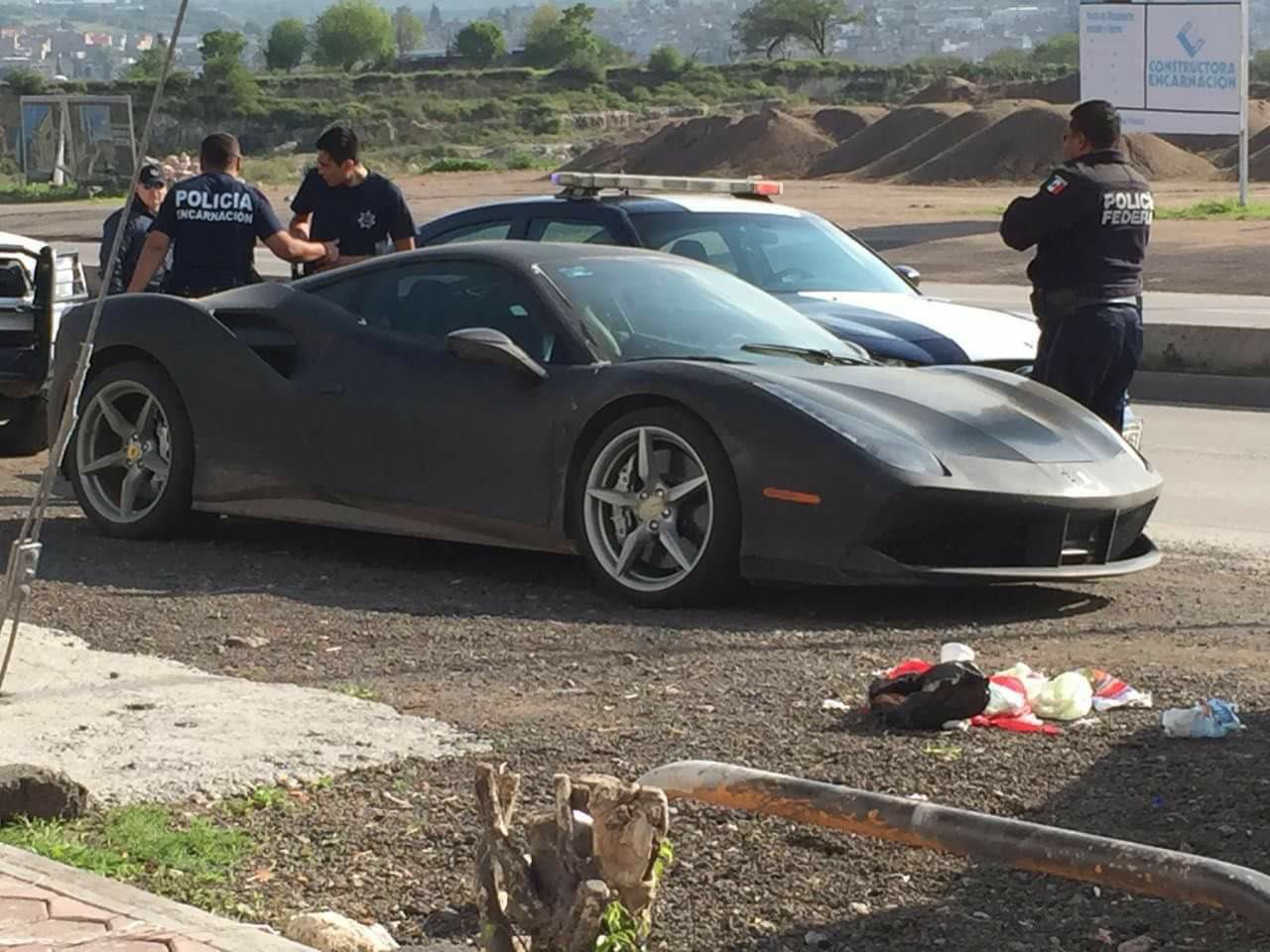 An image of a yellow Ferrari 488 on the side of the road painted black.