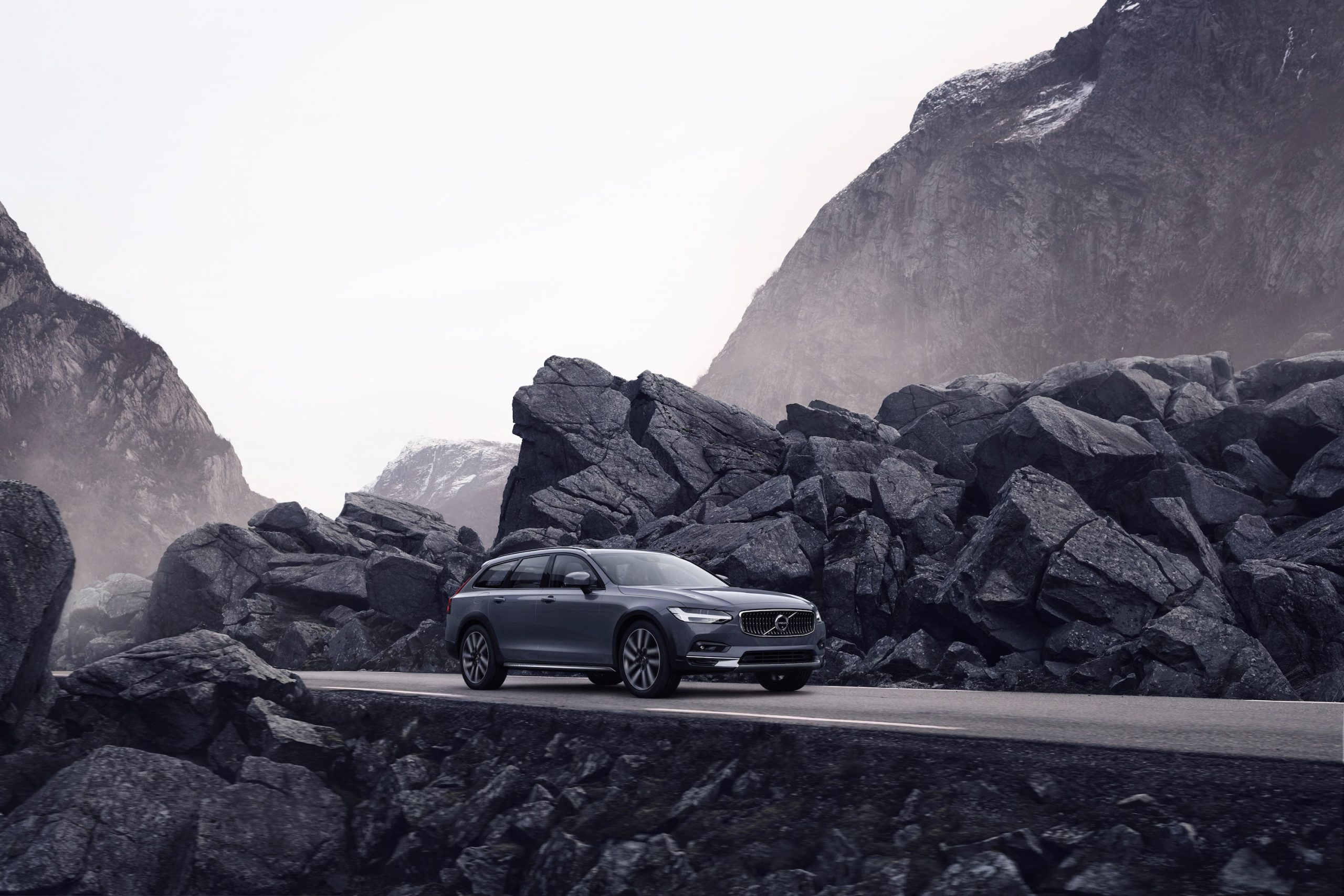grey Volvo driving through the mountains