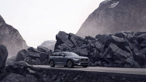 grey Volvo driving through the mountains