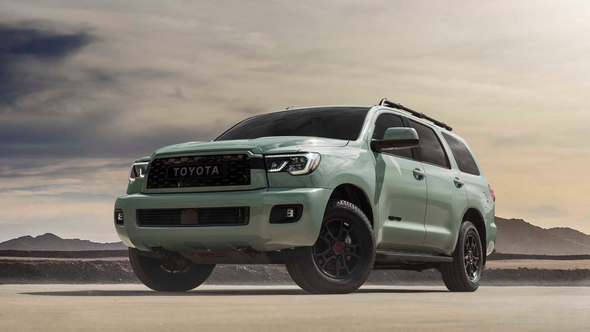 a 2021 toyota sequoia trd pro in Lunar rock in a pale desert showing off its wide, rugged stance. 
