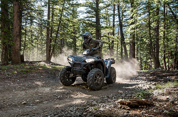 riding the 2021 Polaris Sportsman 1000 ATV in the forest on a trail