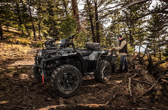 a 2021 Polaris Sportsman XP 1000 ATV towing and hauling in a wooded area 