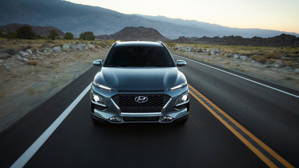 the 2021 hyundai kona in thundra gray driving down an open road showing of its zippy turbo engine